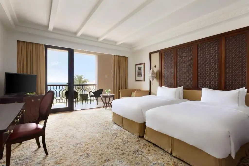 Geräumiges Schlafzimmer der Deluxe Suite mit zwei Einzelbetten und Meerblick