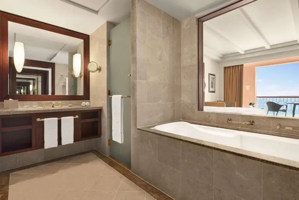 Elegantes Badezimmer in der Deluxe Suite mit Badewanne und edlen Armaturen
