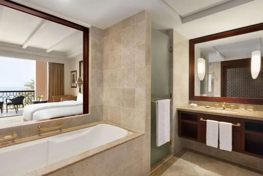 Luxuriöses Badezimmer mit Badewanne und Blick ins Schlafzimmer, stilvolle Einrichtung