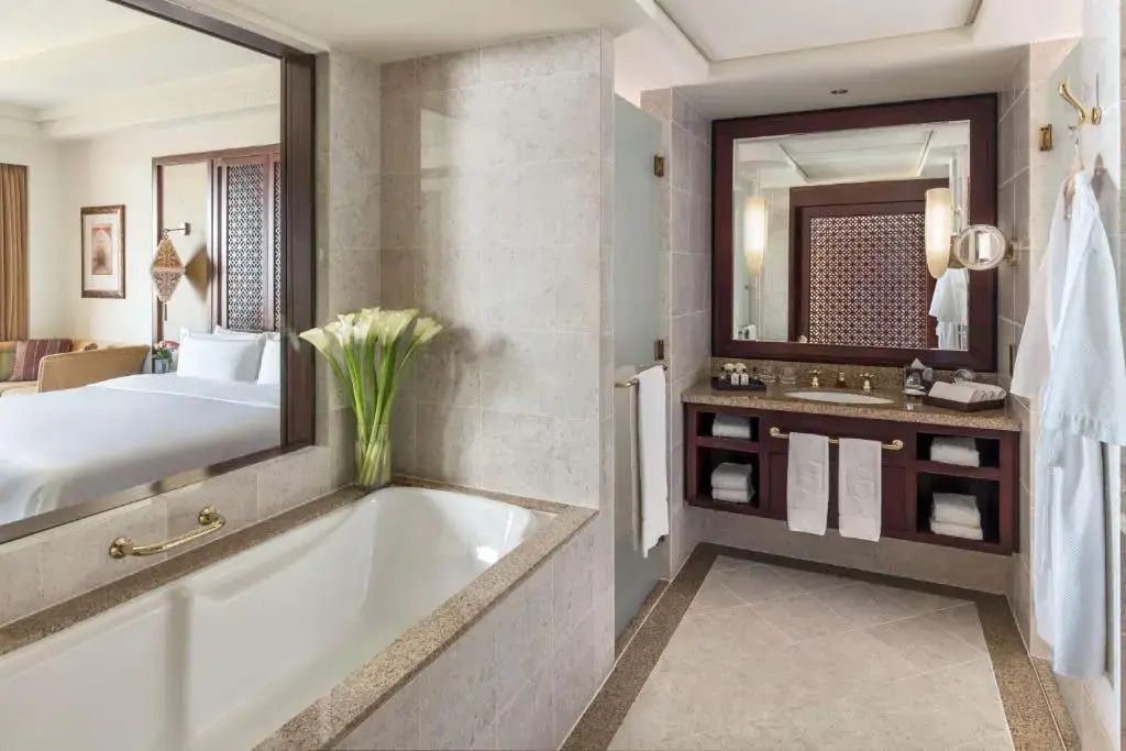 Modernes Badezimmer mit eleganter Badewanne, großer Spiegel und schicke Details
