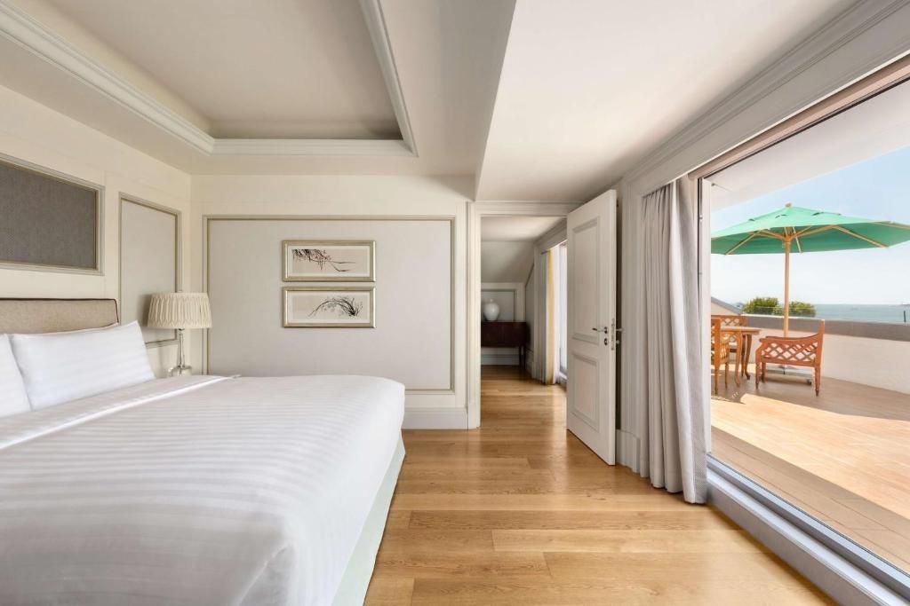 Helles Schlafzimmer mit Doppelbett und Zugang zur Terrasse in der Barbaros Suite