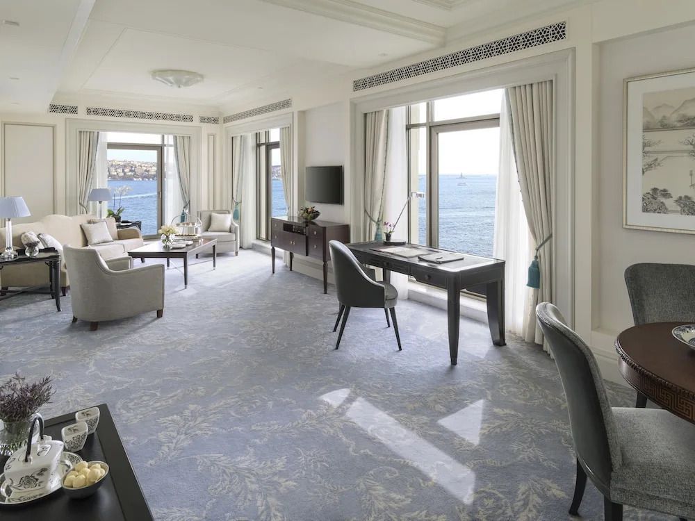 Luxuriöses Wohnzimmer mit Panoramafenster und Blick aufs Meer.
