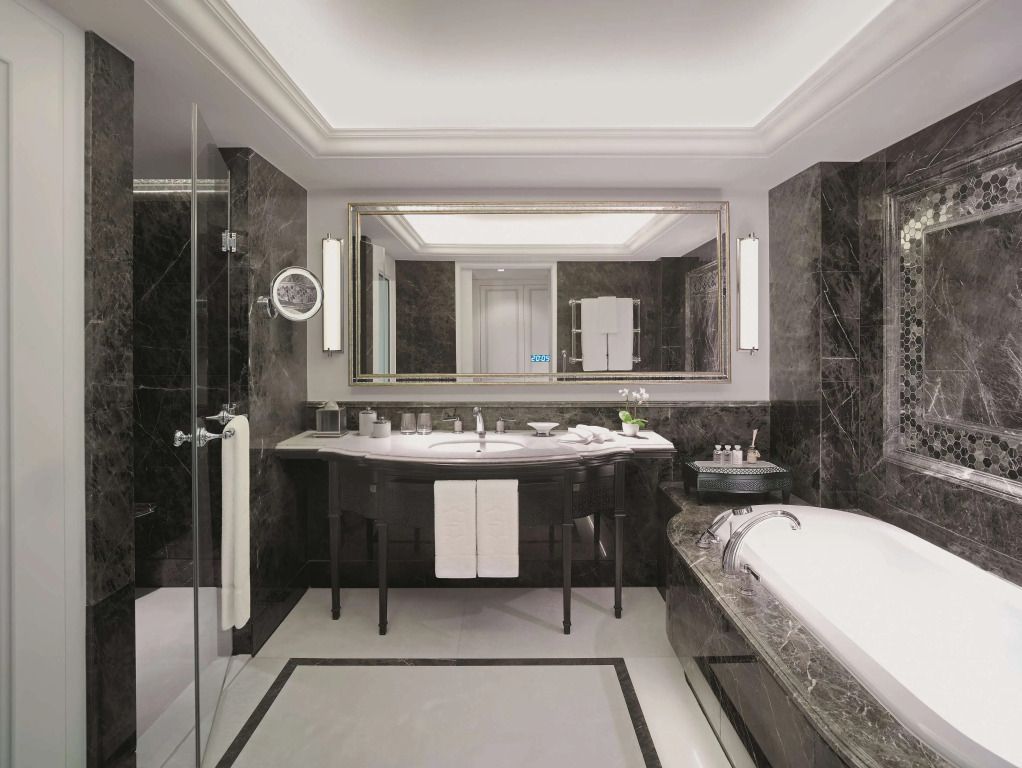 Luxuriöses Badezimmer mit Marmorverkleidung und großer Badewanne