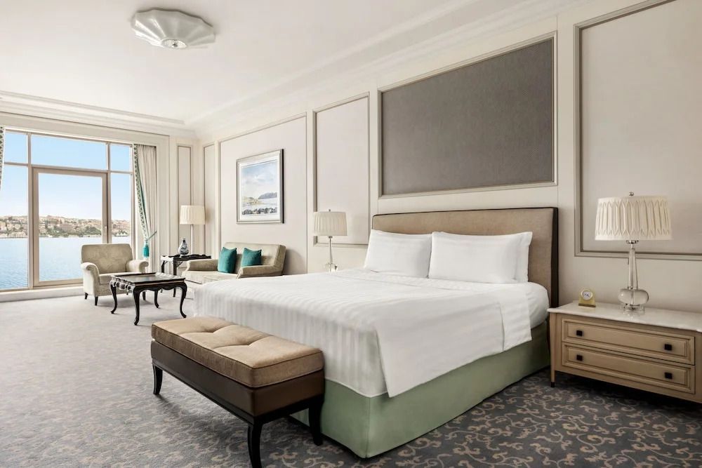Elegantes Zimmer mit Doppelbett und gemütlicher Sitzecke.