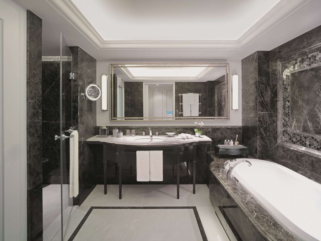 Luxuriöses Badezimmer mit Marmorverkleidung und großer Badewanne.