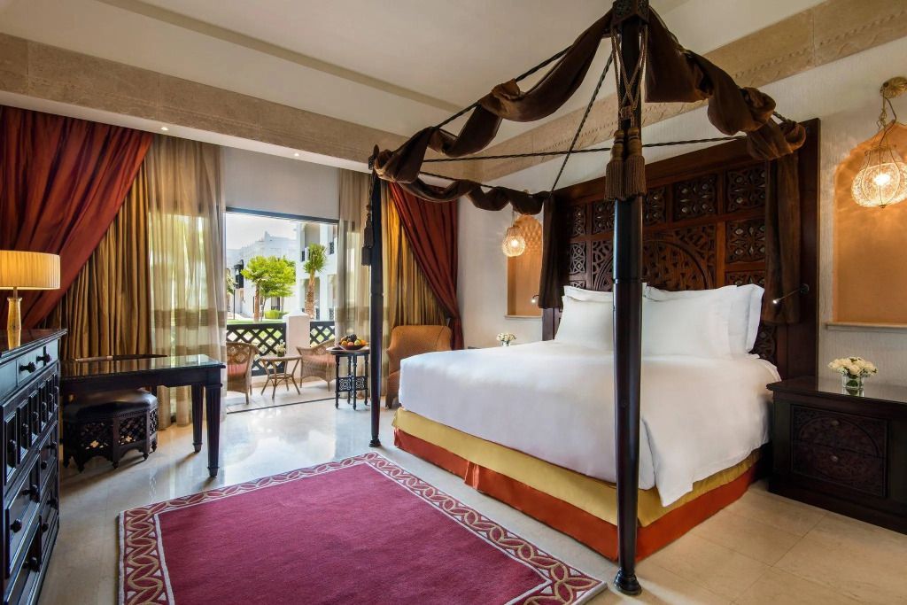 Deluxe Doppelzimmer mit Himmelbett und Balkon mit Gartenblick im Sharq Village & Spa.