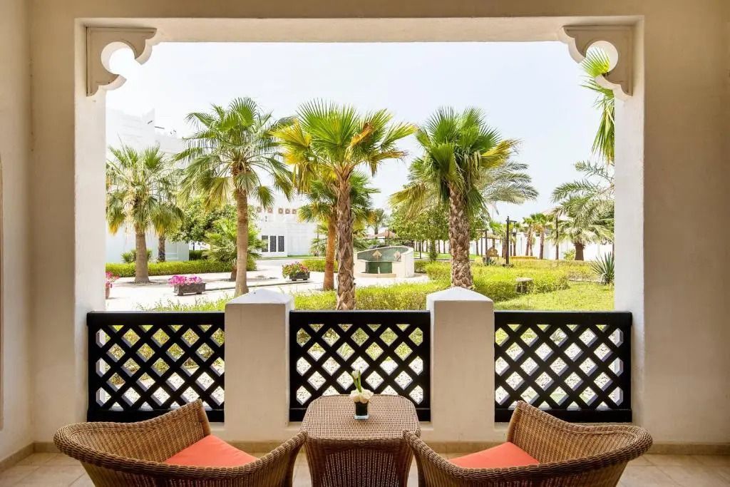 Balkon mit Blick auf palmengesäumten Garten im Sharq Village.