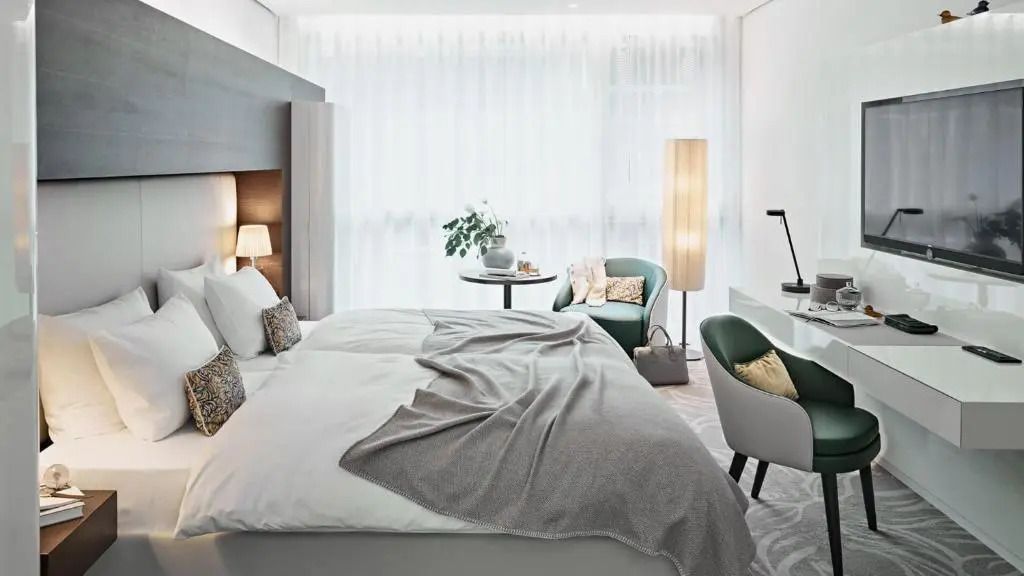 Helles Deluxe-Doppelzimmer mit gemütlichem Bett und Sitzbereich.