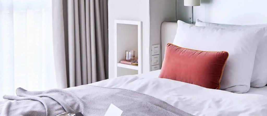 Gemütliches Bett mit eleganten Kissen und minimalistischem Design.