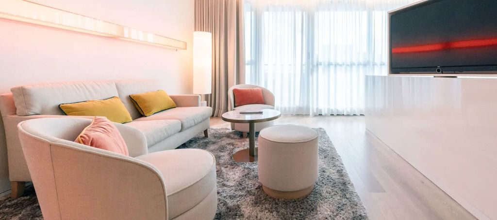 Gemütliche Sitzecke mit Sofa und Sesseln in heller Suite.