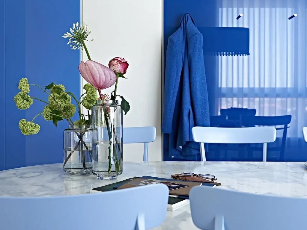 Tisch mit Blumenarrangement und blauen Akzenten im Essbereich