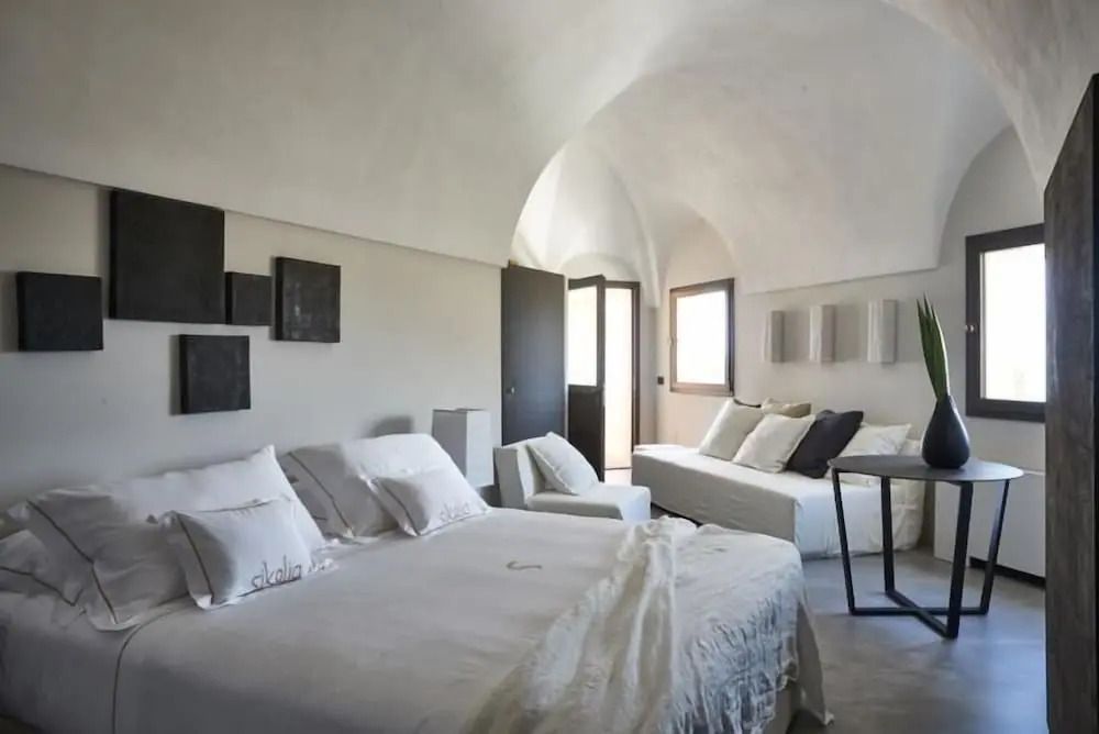 Helles Schlafzimmer mit Sicht auf zwei Betten unter einem Gewölbedach.