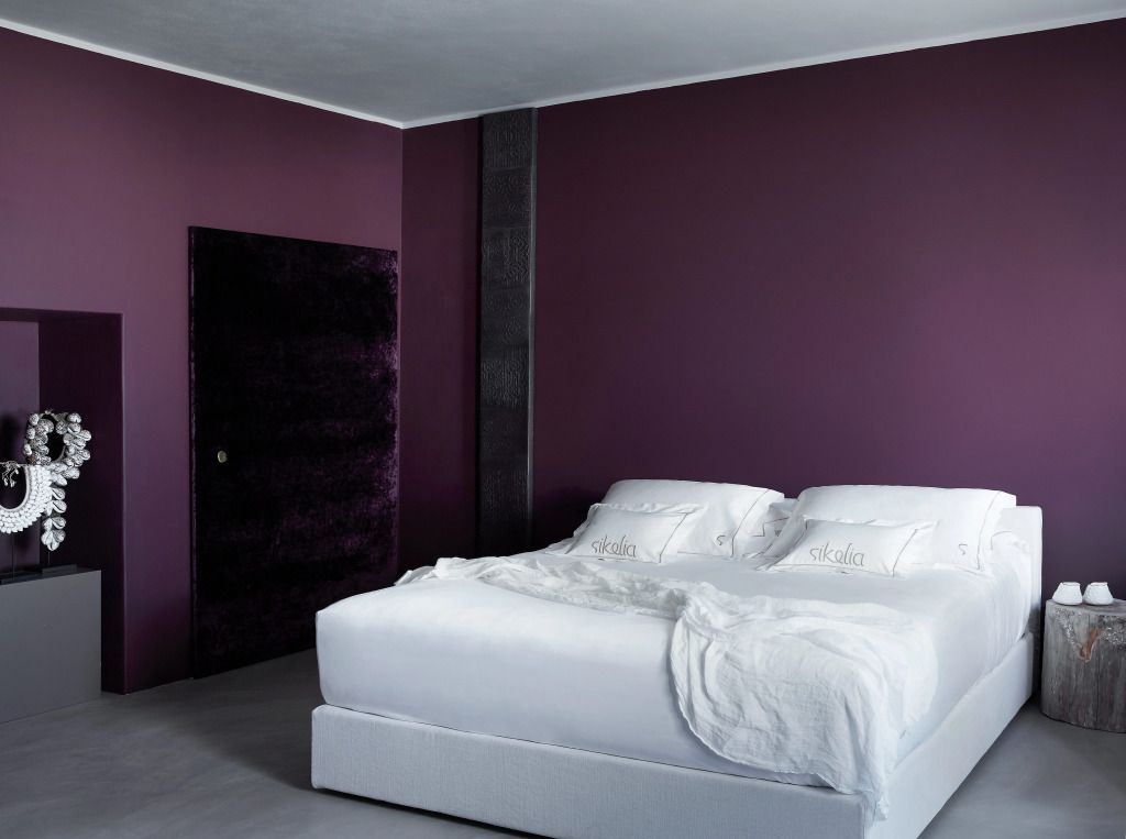 Elegante Junior-Suite mit lila Wänden und komfortablem Doppelbett im Sikelia Luxury Retreat
