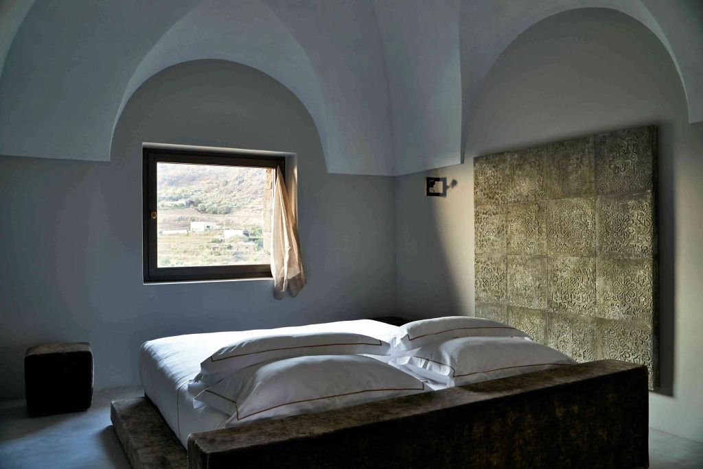 Minimalistisch eingerichtetes Schlafzimmer mit Kingsize-Bett und großem Fenster.