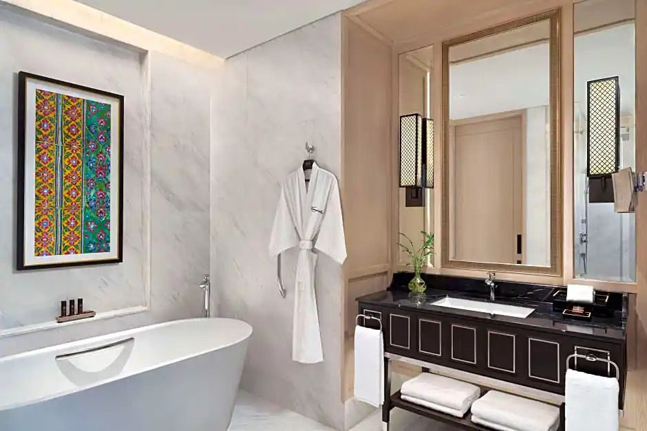 Modernes Badezimmer mit freistehender Badewanne, Marmorwänden und luxuriösen Details.