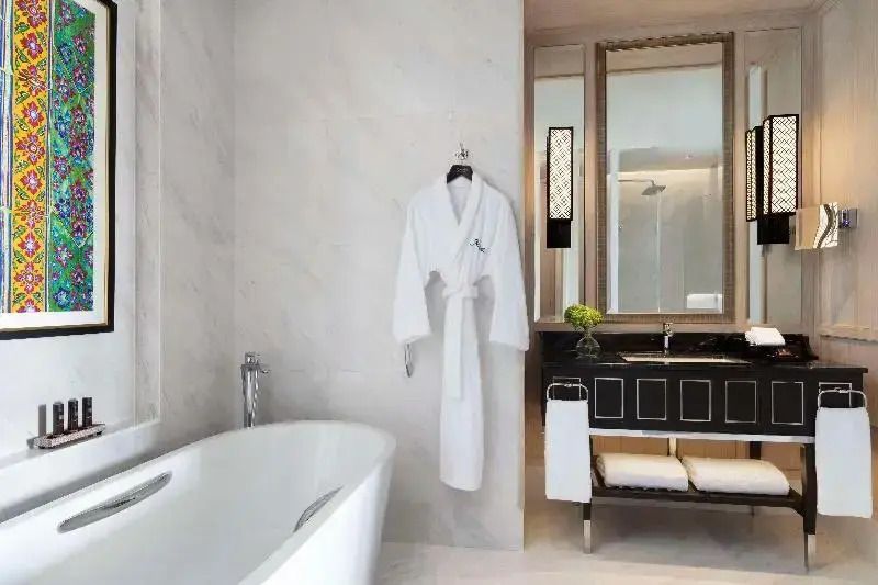Badezimmer mit moderner Badewanne, Bademantel und stilvollen Armaturen.
