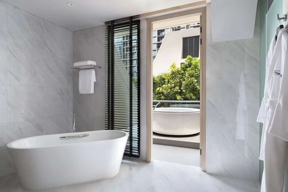 Modernes Badezimmer der Sindhorn Royal Suite mit Badewanne und Zugang zum Balkon.