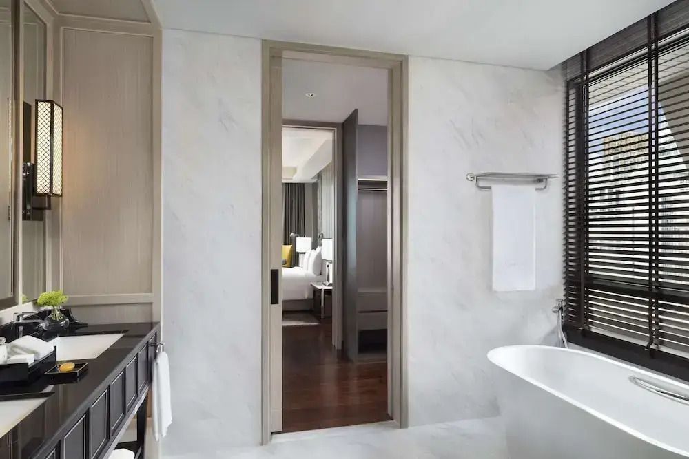 Helles Badezimmer der Sindhorn Suite mit Badewanne und Zugang zum Schlafzimmer.