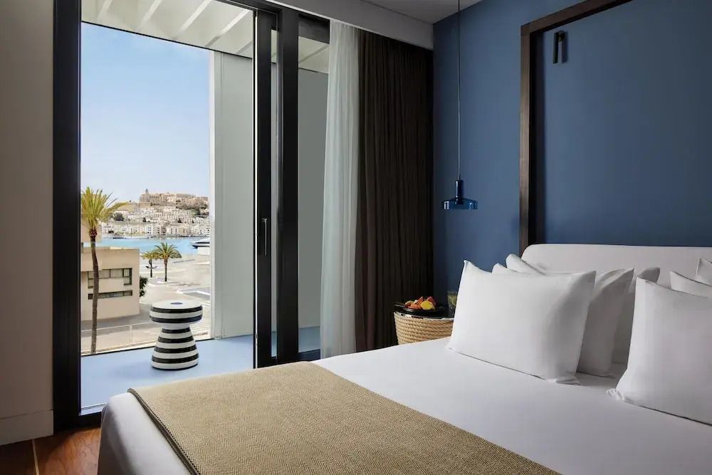 Modernes Zimmer mit Blick auf die Terrasse und das Meer, hell eingerichtet.