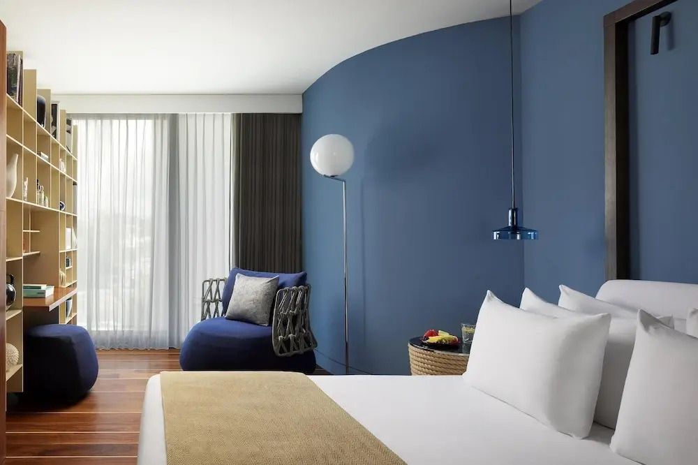 Geräumiges Zimmer mit stilvollem Sessel und blauer Akzentwand.