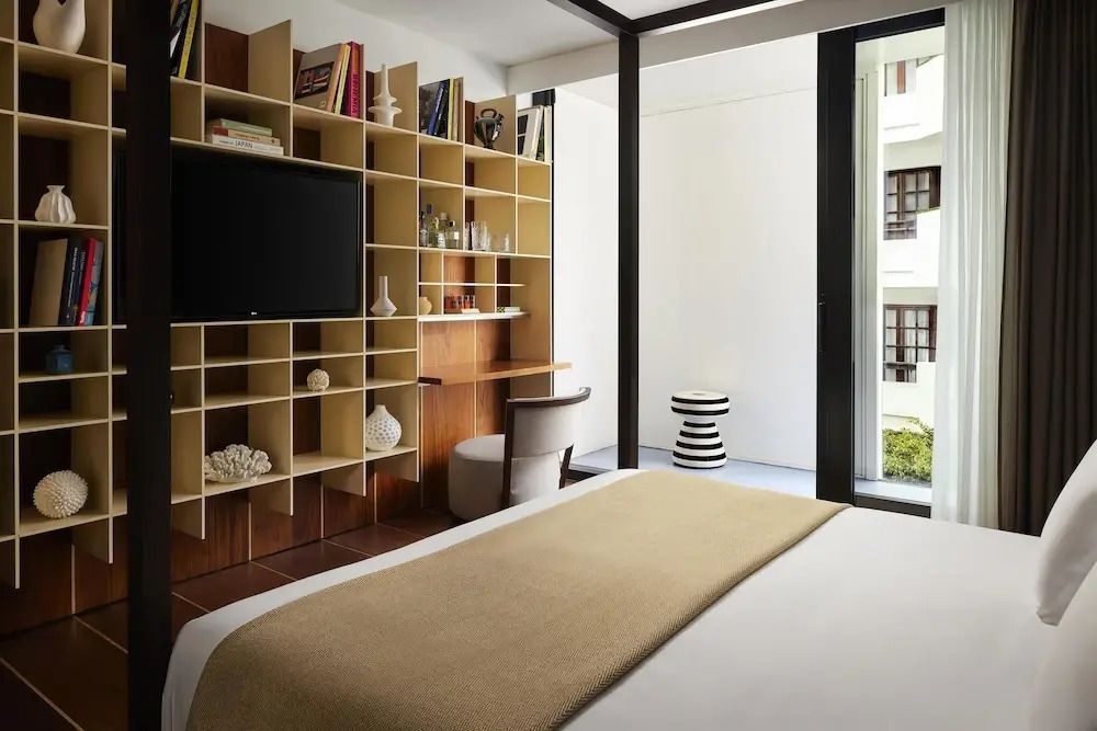 Geräumiges Zimmer mit Regalwand, Flachbildfernseher und Schreibtisch