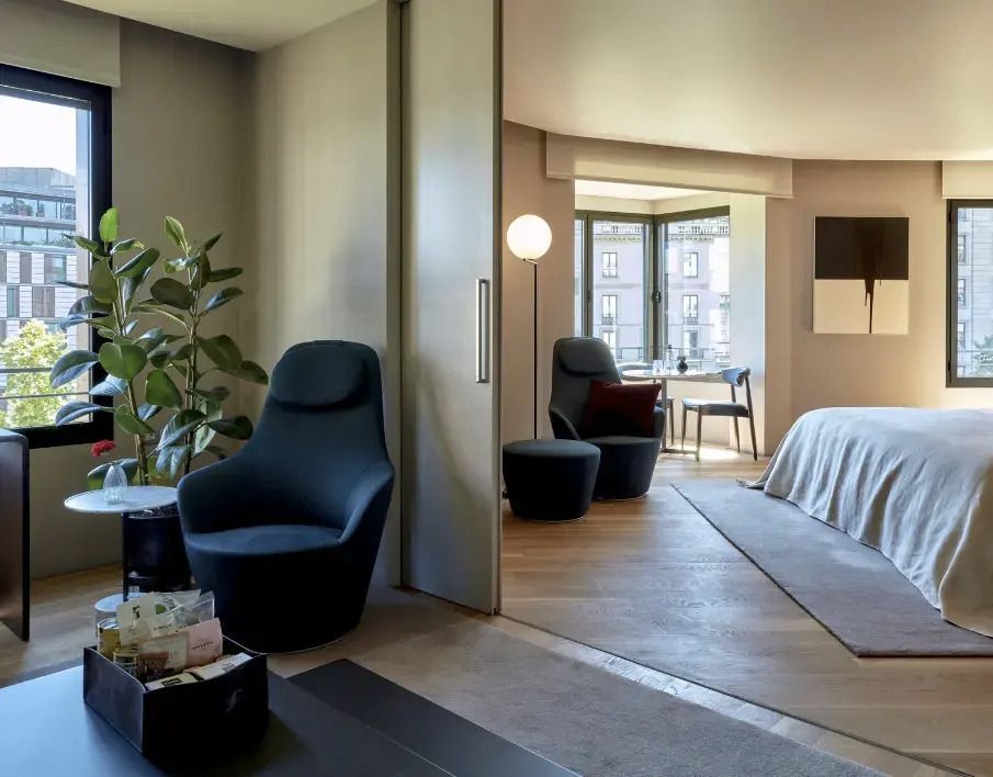 Offen gestaltete Suite mit Sitzbereich und Bett im Hotel Sir Victor