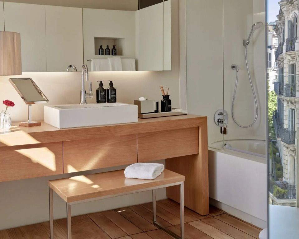 Badezimmer im Sir Victor Hotel mit Badewanne und Holzdetails