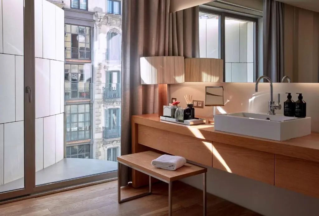 Eckbereich mit großem Fenster und stilvollem Waschtisch im modernen Hotelzimmer