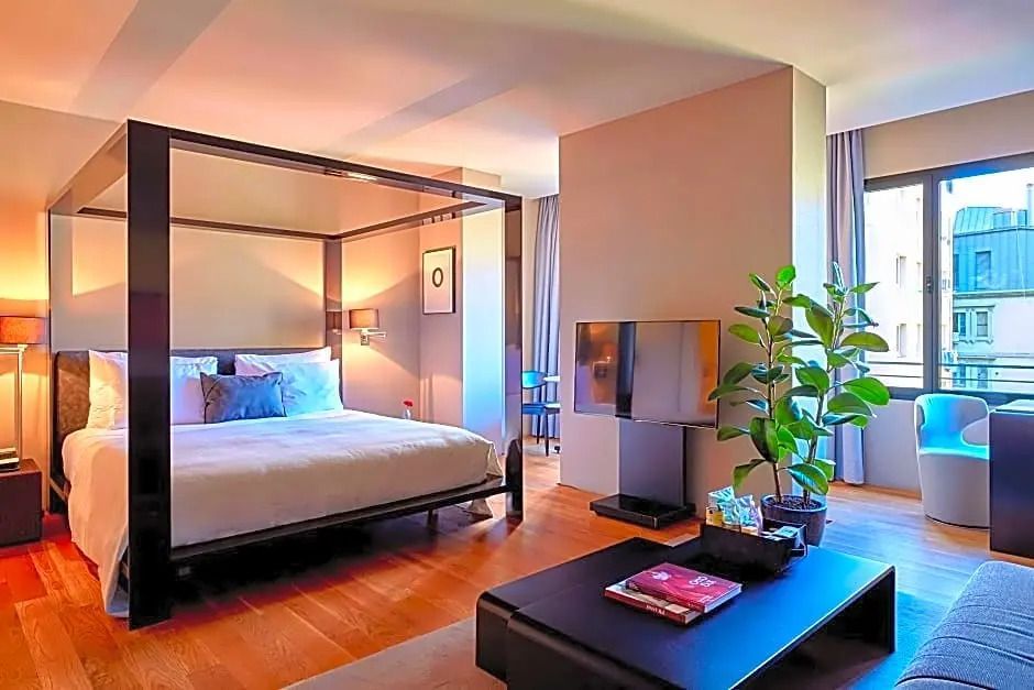 Modernes Zimmer mit Himmelbett und Entertainment-Bereich