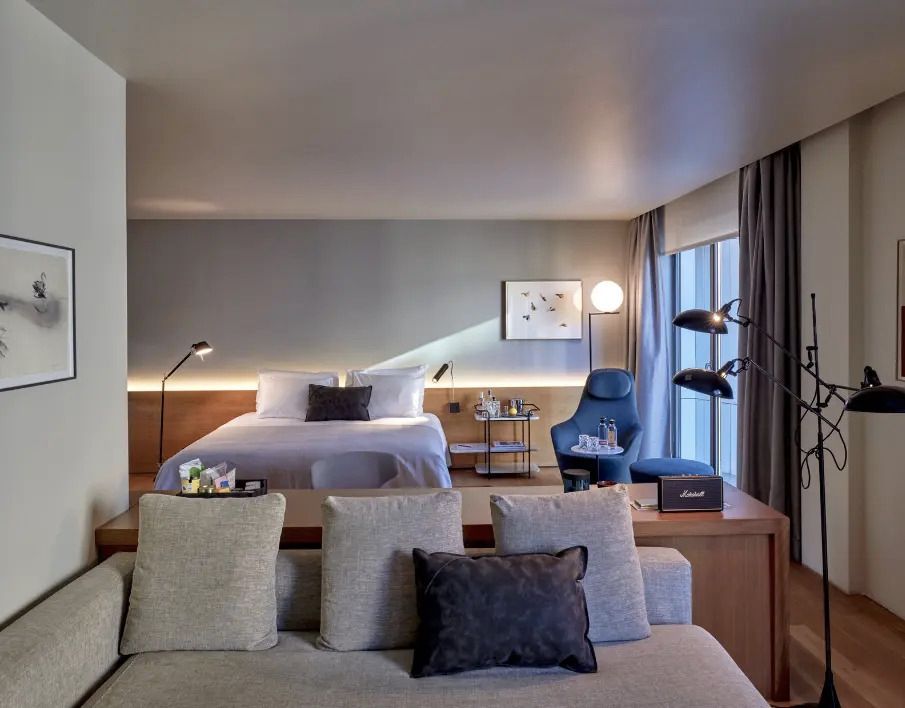 Modern gestaltetes Doppelzimmer mit stilvollem Beleuchtungskonzept und komfortabler Sitzecke