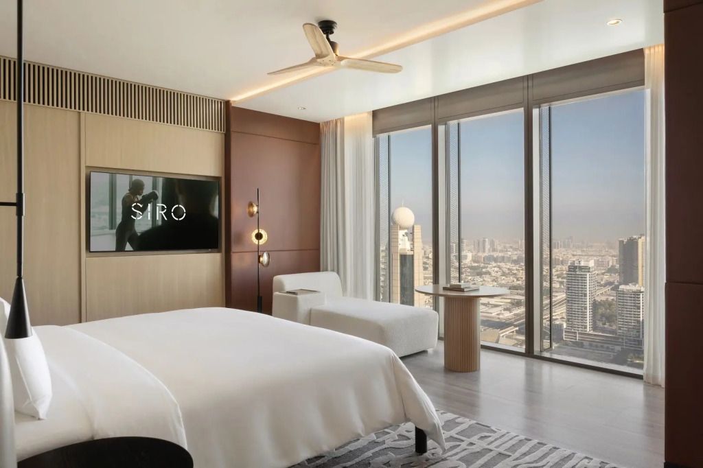 Moderne Suite mit Doppelbett, großen Fenstern und Blick auf Dubais Skyline