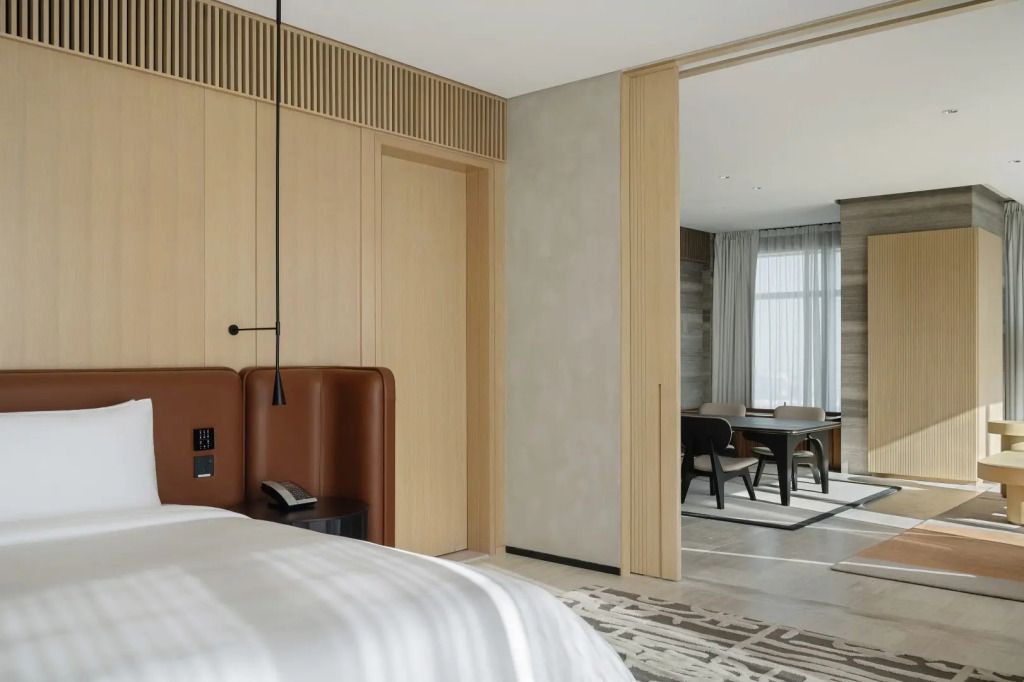 Teilansicht einer Suite mit hölzerner Akzentwand und Zugang zum Wohnbereich