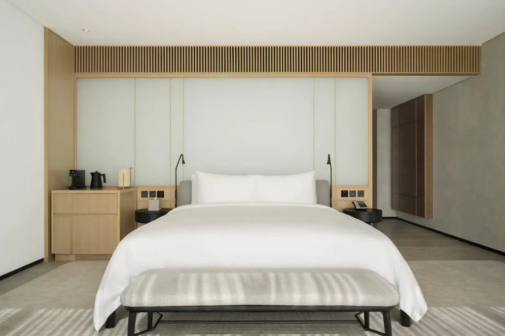 Modernes Hotelzimmer mit großem Doppelbett und minimalistischem Design