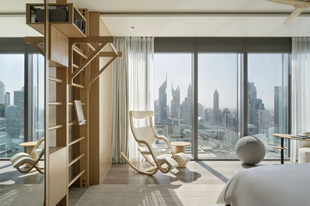Großes Fenster mit Blick auf Dubai-Skyline und Schaukelstuhl im Zimmer