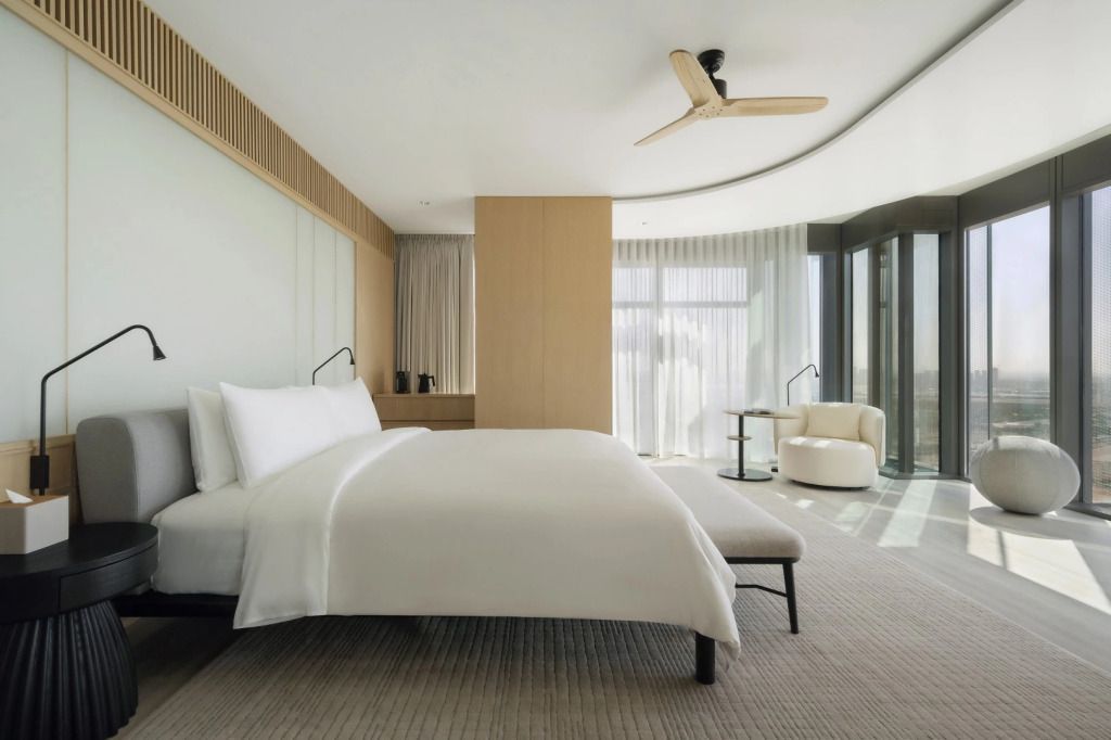 Helles Zimmer mit großen Fenstern und elegantem Doppelbett