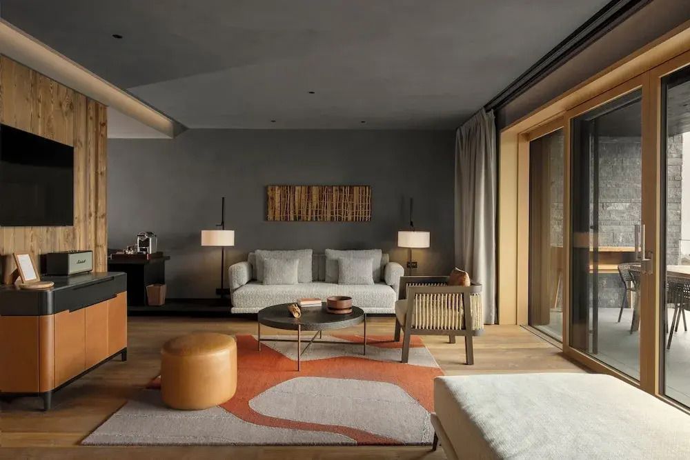 Moderner Lounge-Bereich mit komfortablen Sofas und Zugang zum Balkon in der Suite.