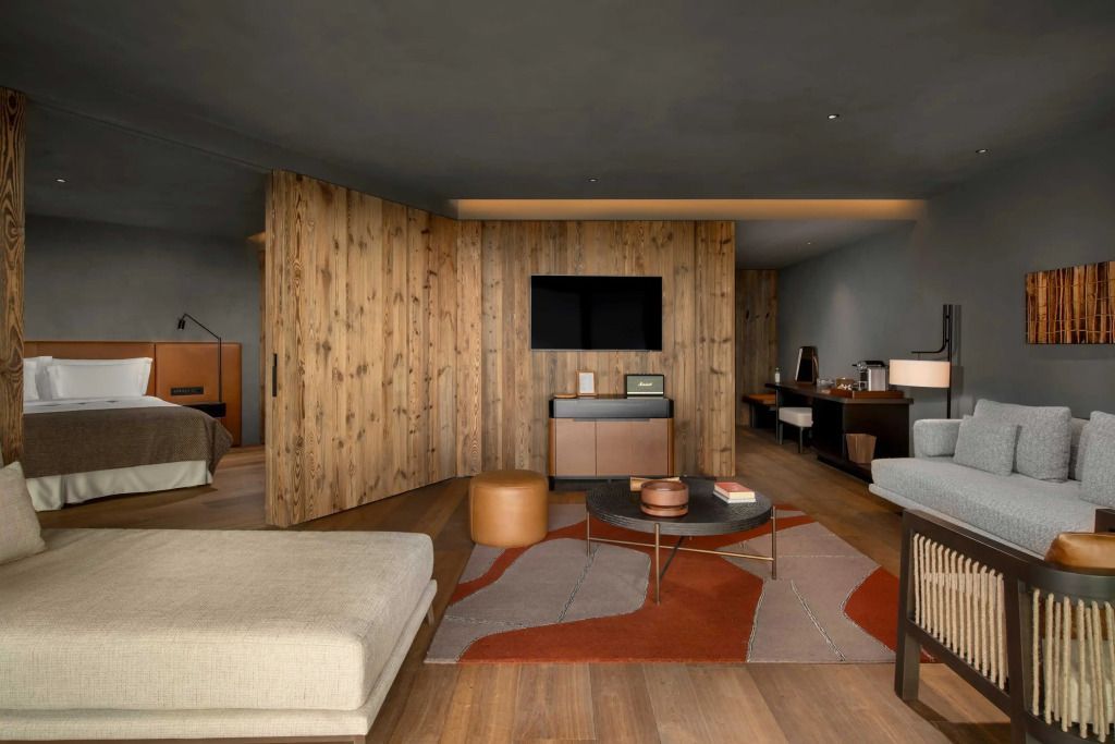 Moderne Suite mit Holzelementen und stilvoller Einrichtung, warmes Licht.