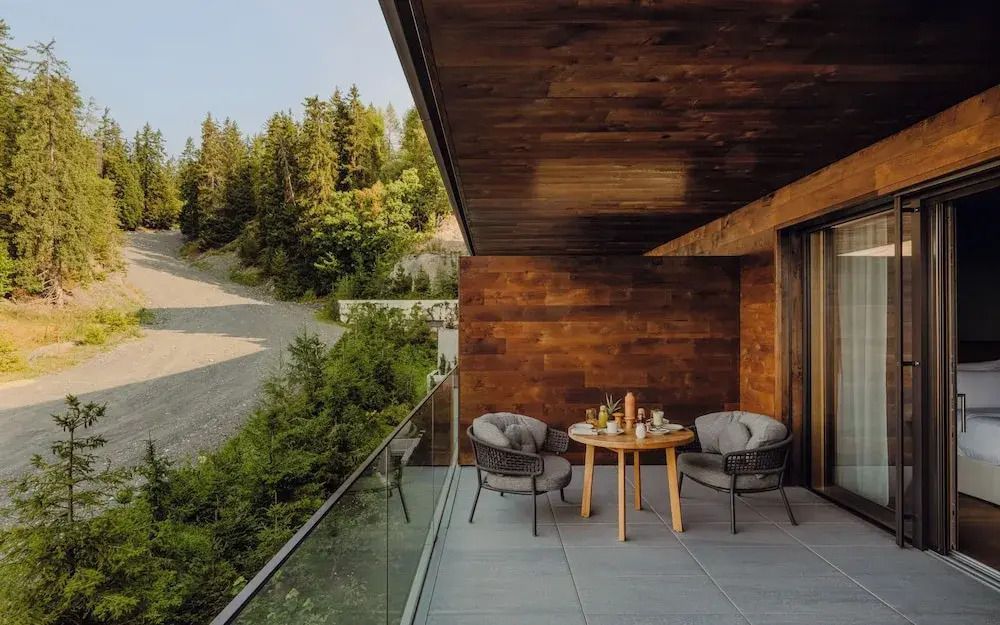 Balkon mit Sitzgelegenheiten und Waldblick im Sommer