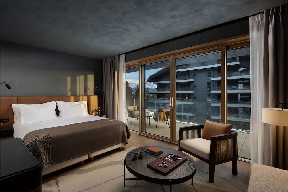 Elegantes Schlafzimmer mit großem Bett und Balkonblick auf moderne Architektur