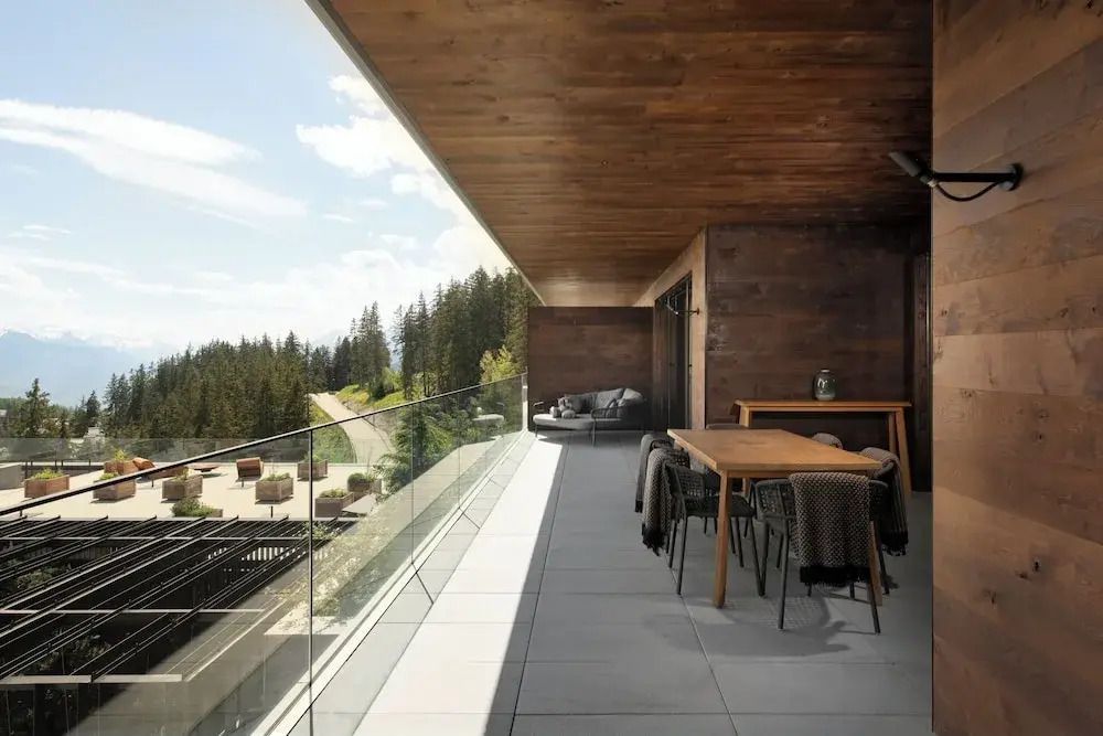 Großer Balkon mit Sitzmöbeln und Panoramablick auf die Alpen