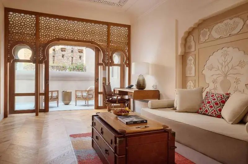 Wohnbereich der Suite mit traditionellen Holzmöbeln und heller Dekoration