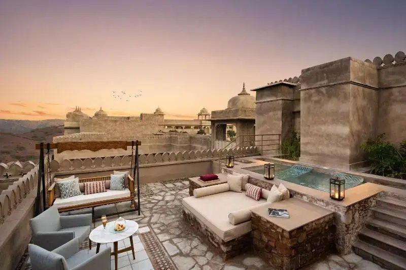 Rooftop-Terrasse mit Sitzbereich und Pool im Six Senses Fort Barwara bei Dämmerung