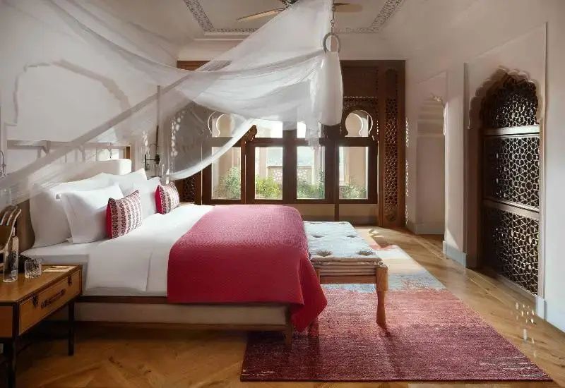 Luxus-Suite Schlafzimmer mit Baldachin, roten Akzenten und Holzboden
