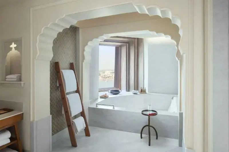 Helles Badezimmer mit großer Badewanne und Fensterblick