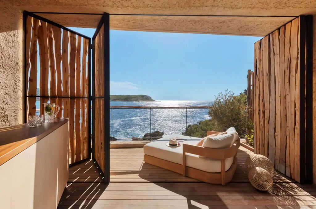 Terrasse einer Suite mit Liegestuhl und Blick auf das Meer bei Sonnenschein
