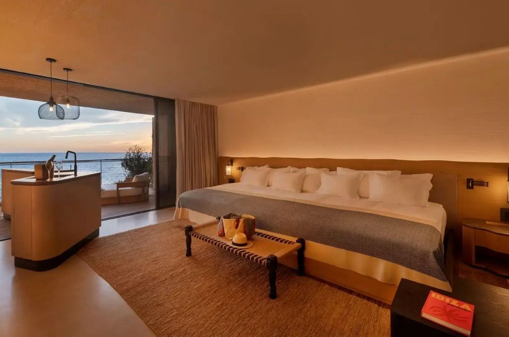 Großes Bett in einer modernen Suite mit Meerblick bei Abendstimmung