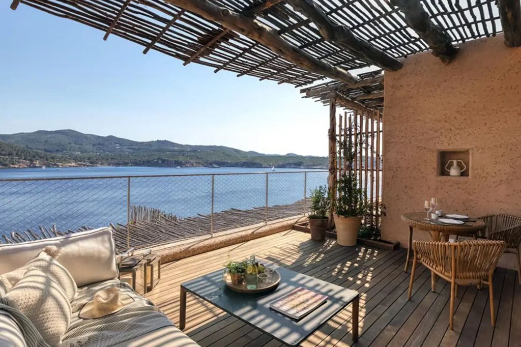 Holzterrasse mit Sitzgelegenheiten und atemberaubendem Blick auf das Meer