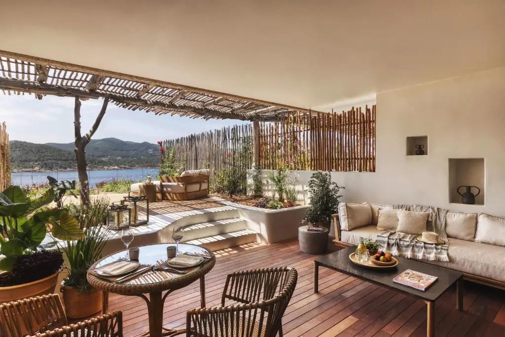 Geräumige Terrasse mit Meerblick, gemütlicher Sitzecke und Holzboden, perfekt zum Entspannen.