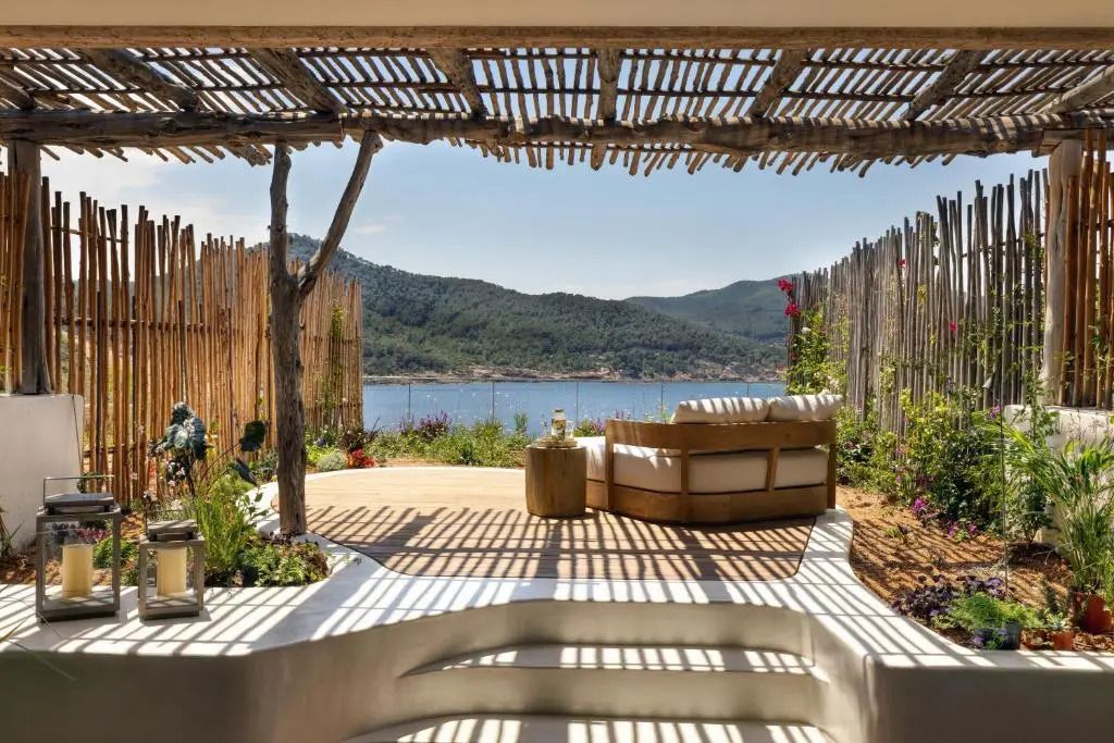 Terrasse mit atemberaubendem Blick auf das Meer und idyllischer Sitzlounge unter Holzpergola.