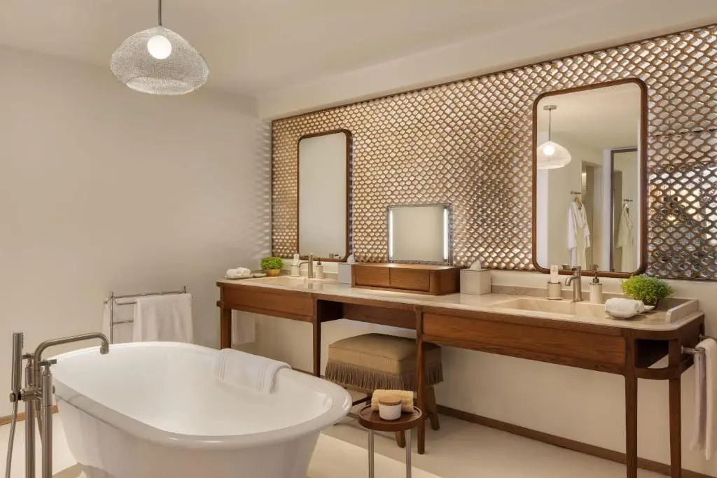 Modernes Badezimmer mit freistehender Badewanne, Doppelwaschbecken und stilvollen Holzakzenten.
